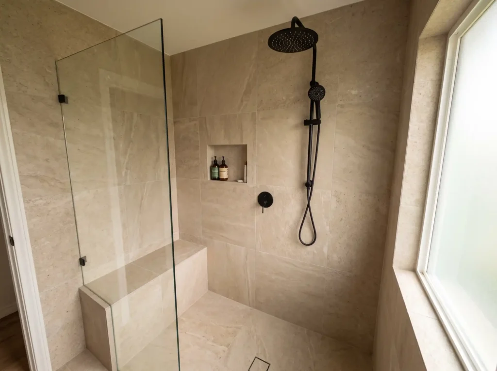 Curbless walk-in shower conversion with matte black fixtures